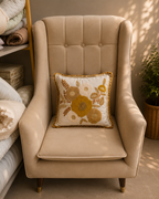 Cream cushion cover with mustard, beige and brown floral embroidery on a beige chair
