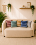 Multicolour velvet cushion covers in rose, sage, mustard, blue and silver grey on a cream sofa