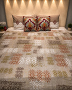 Warm beige ikat-print bedsheet set with rust, olive and brown geometric motifs and coordinated decorative pillow covers