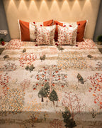 Cream woodland printed bedsheet set with rust orange, olive green and grey tree motifs and coordinated tassel pillow covers by Rituxe Living