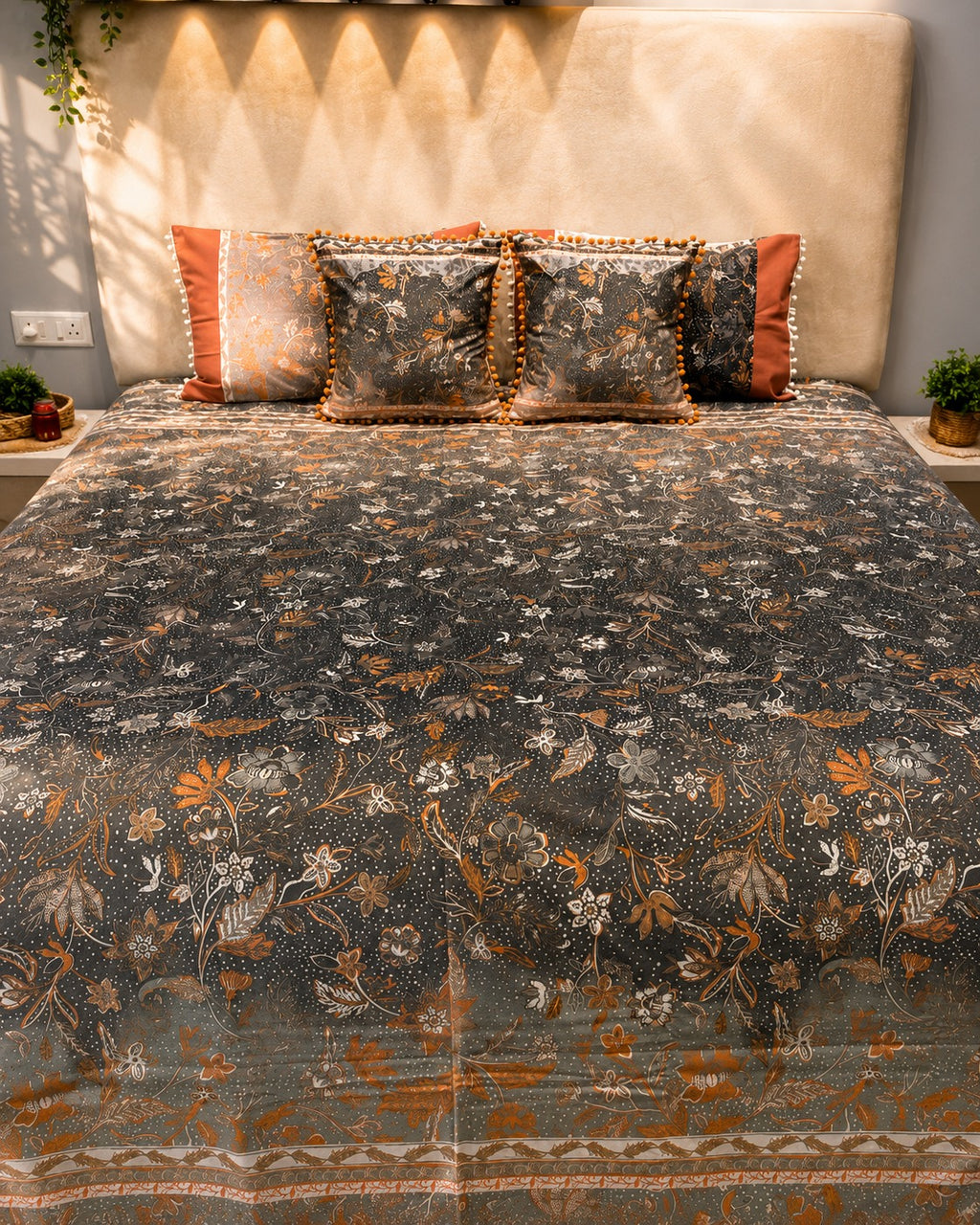 Charcoal grey floral bedsheet set with rust-orange accents and pom-pom decorative pillow covers by Rituxe Living