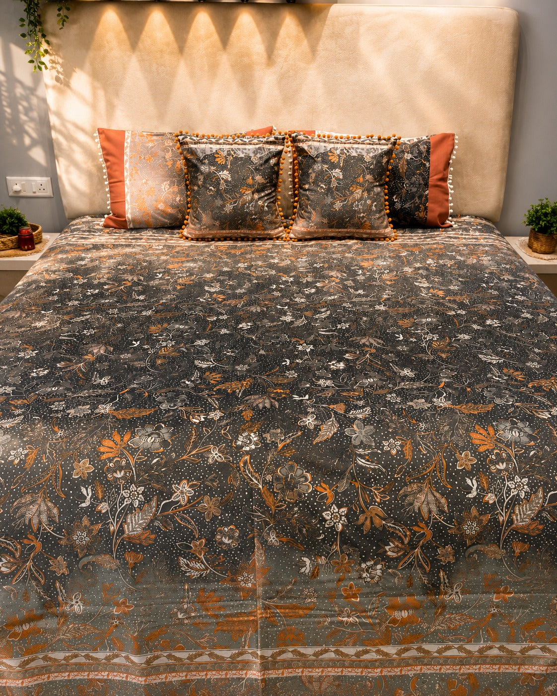 Charcoal grey floral bedsheet set with rust-orange accents and pom-pom decorative pillow covers by Rituxe Living