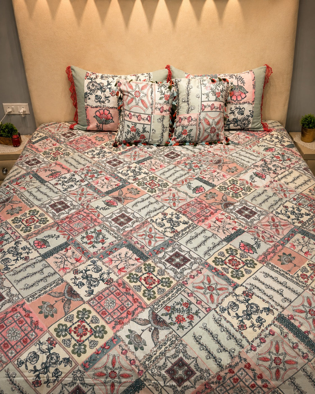 Cream floral patchwork bedsheet set with coral, slate-blue and sage motifs and coordinated tassel pillow covers by Rituxe Living