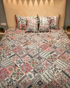 Cream floral patchwork bedsheet set with coral, slate-blue and sage motifs and coordinated tassel pillow covers by Rituxe Living