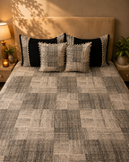 Black and beige geometric bed ensemble with matching pom-pom cushion covers