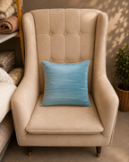 Sky blue velvet cushion cover with gold piping on a cream chair